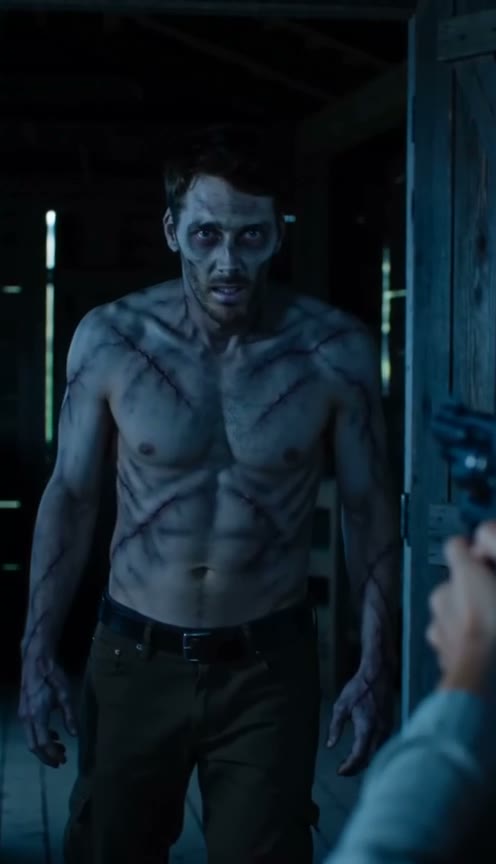 At around two seconds, the shirtless zombie partner stands in the dim cabin opposite the human partner.